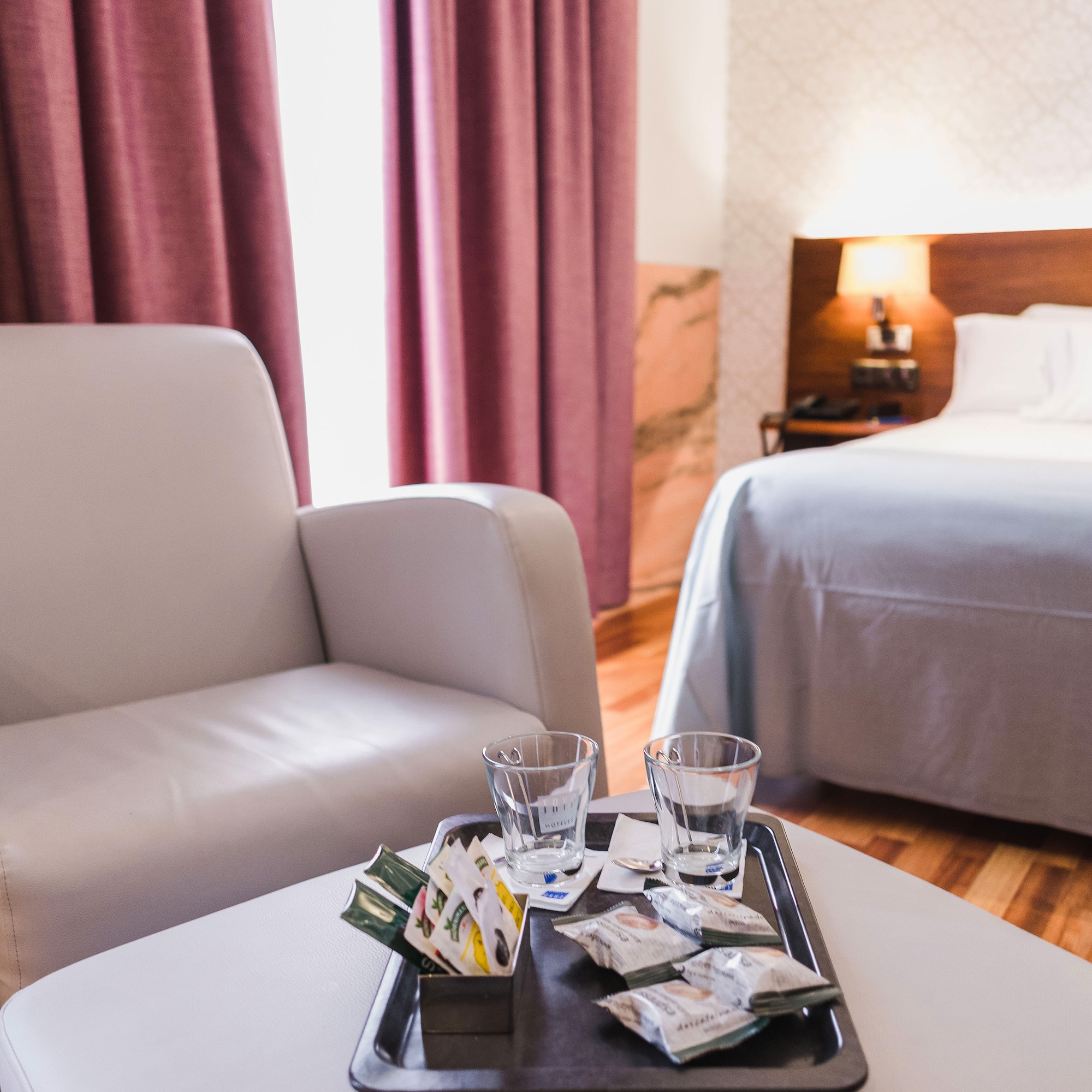 a tray with drinks and glasses on it in a hotel room