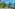 a beach with chairs and umbrellas and trees