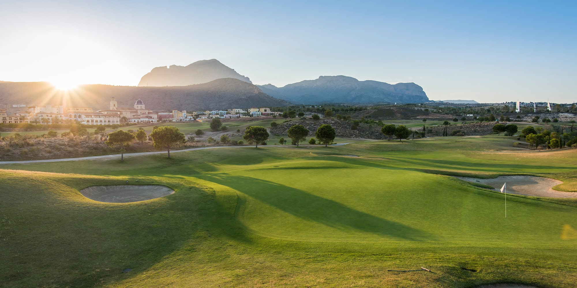a golf course with a city in the background