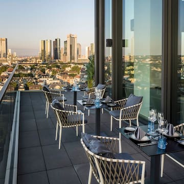 a table and chairs on a rooftop overlooking a city