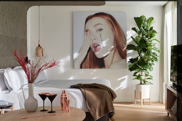 a room with a bed and a picture of a woman