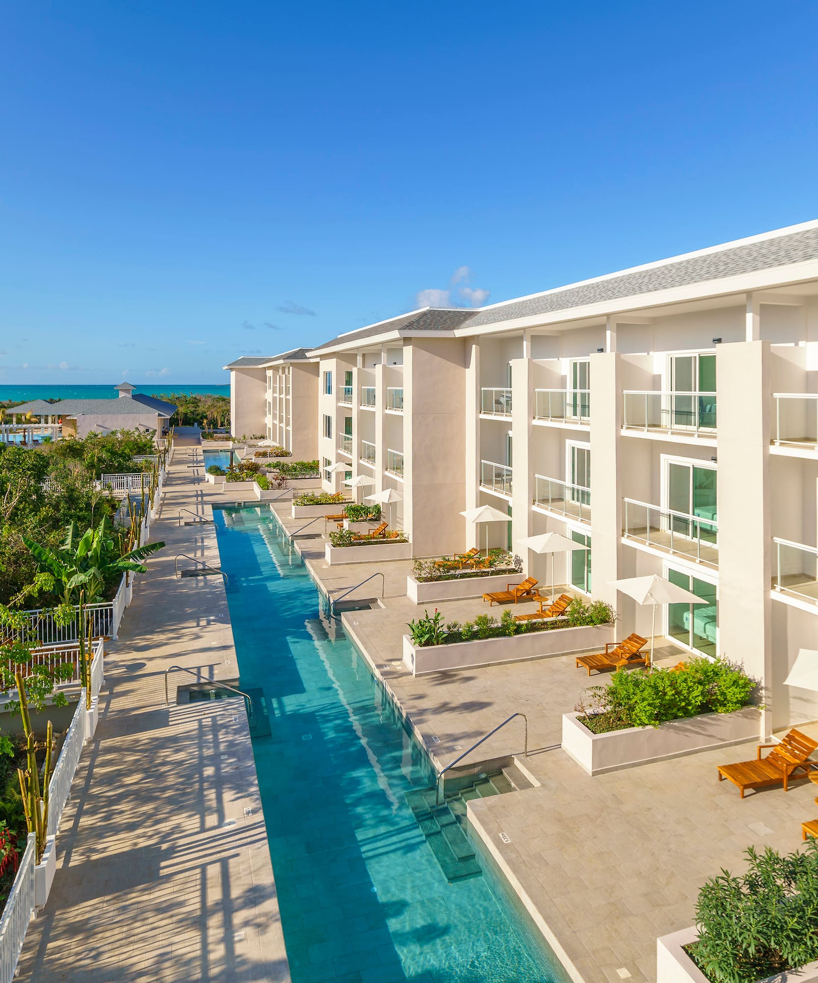 a swimming pool with chairs and trees in the background