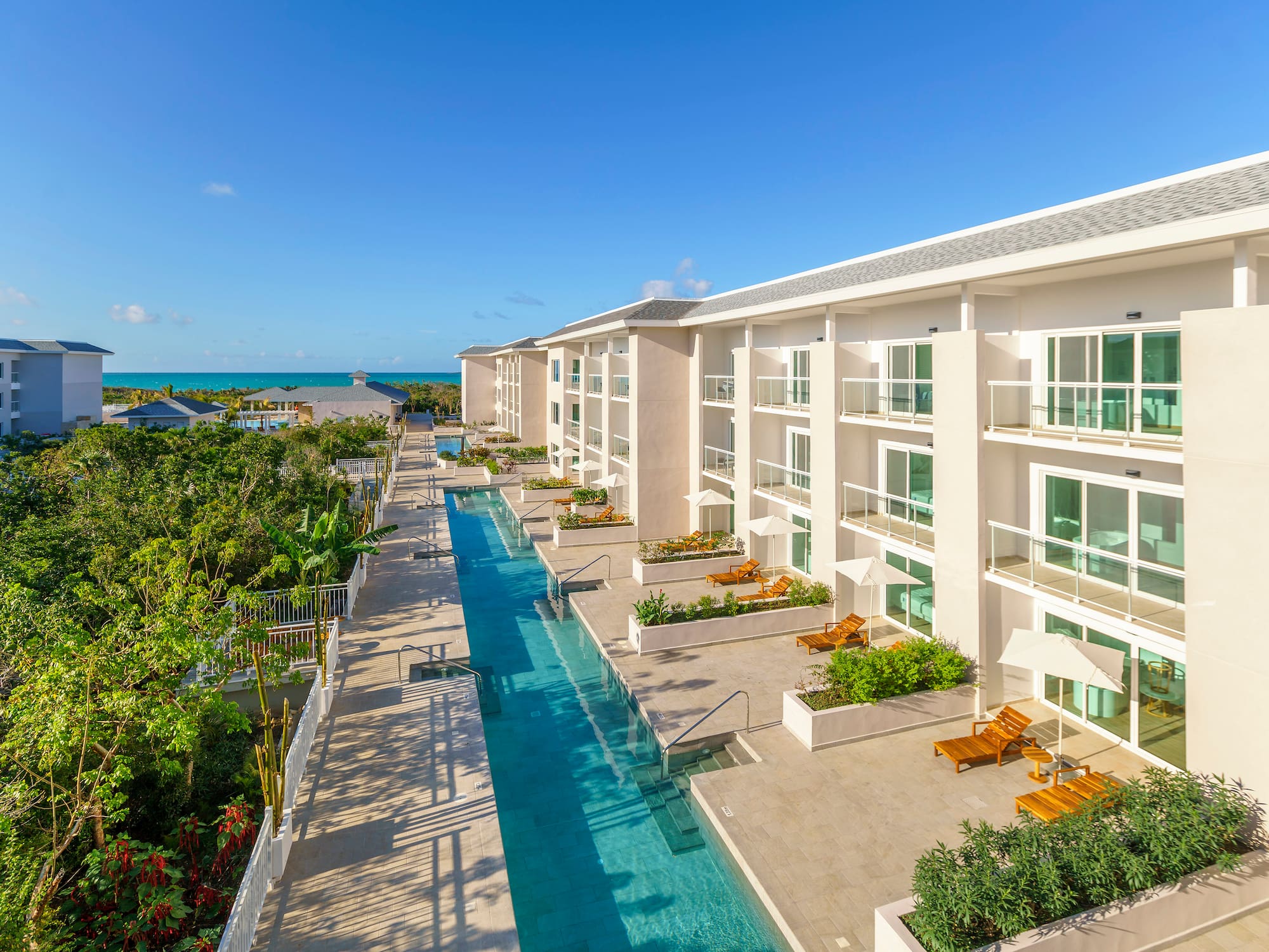a swimming pool with chairs and trees in the background