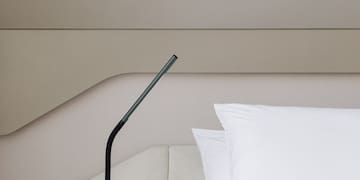 a black lamp on a bed