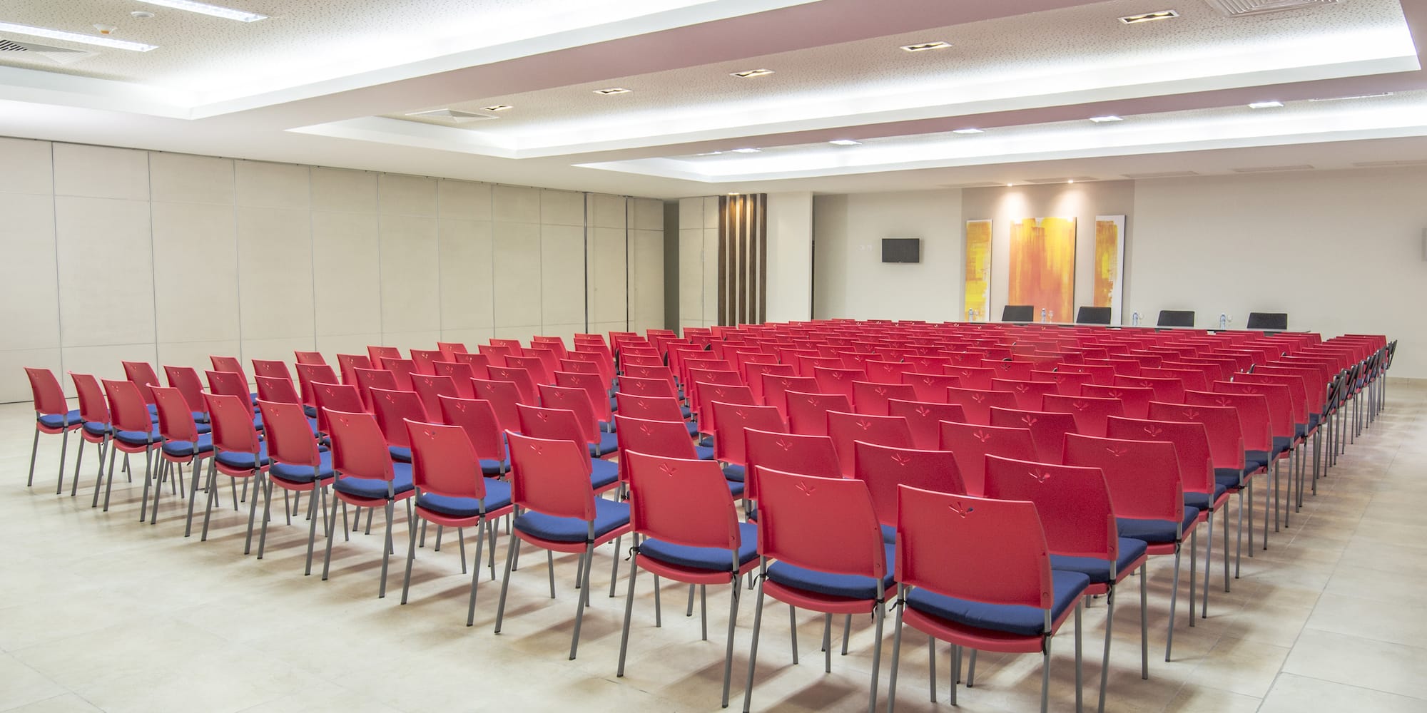 a room with rows of red chairs
