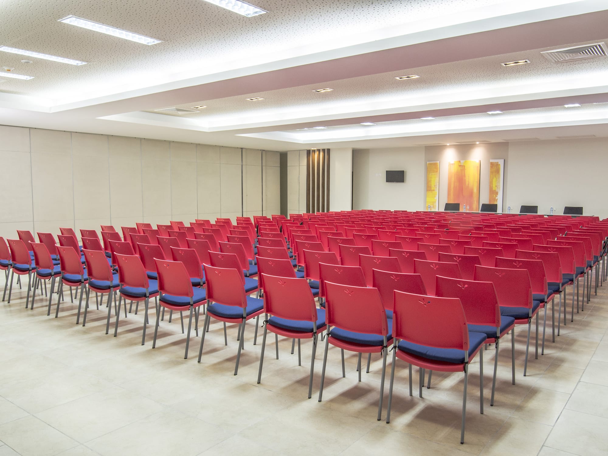 a room with rows of red chairs
