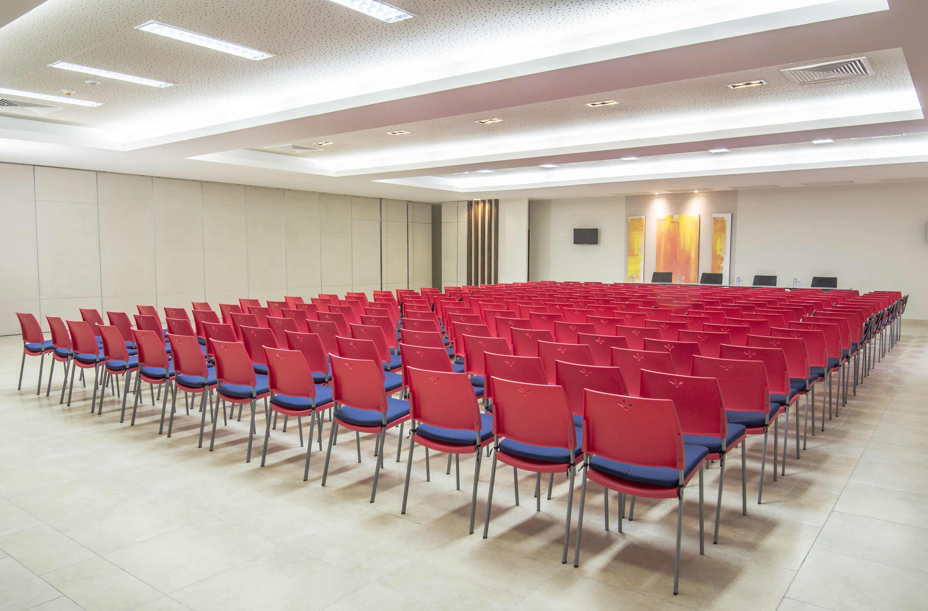 a room with rows of red chairs