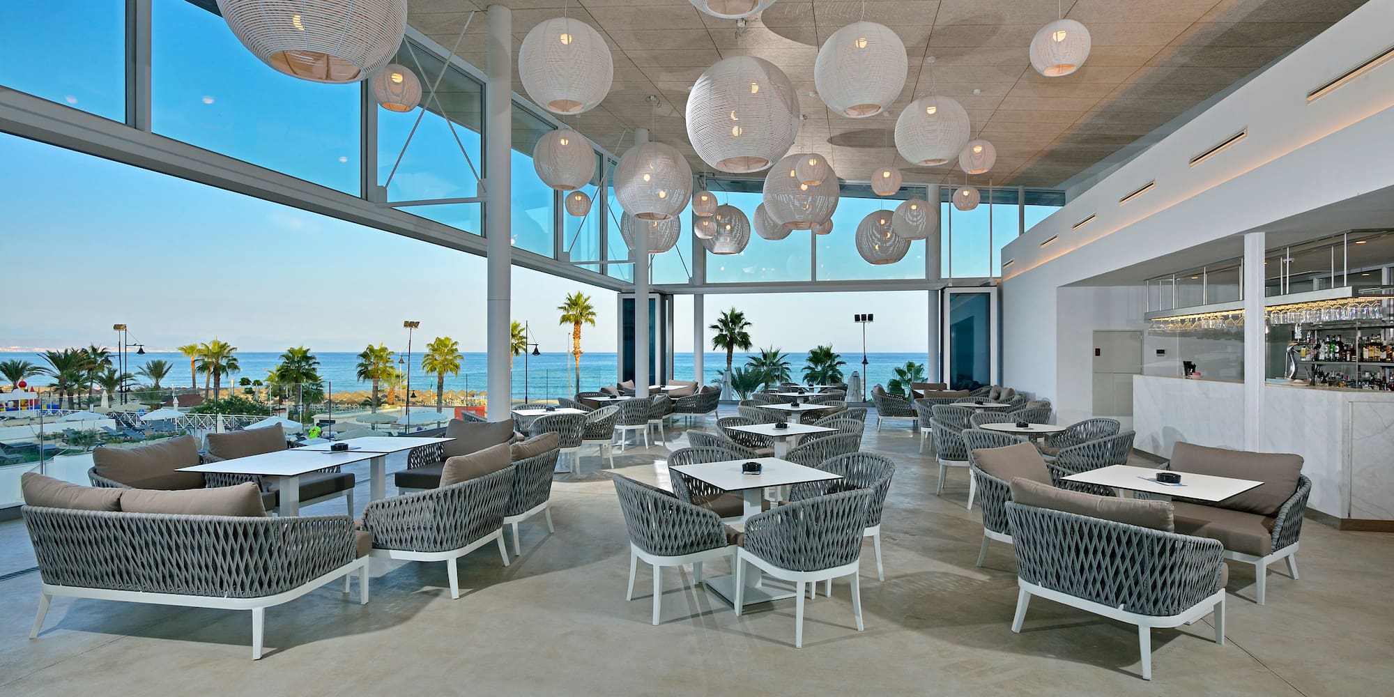 a room with tables and chairs and a large window