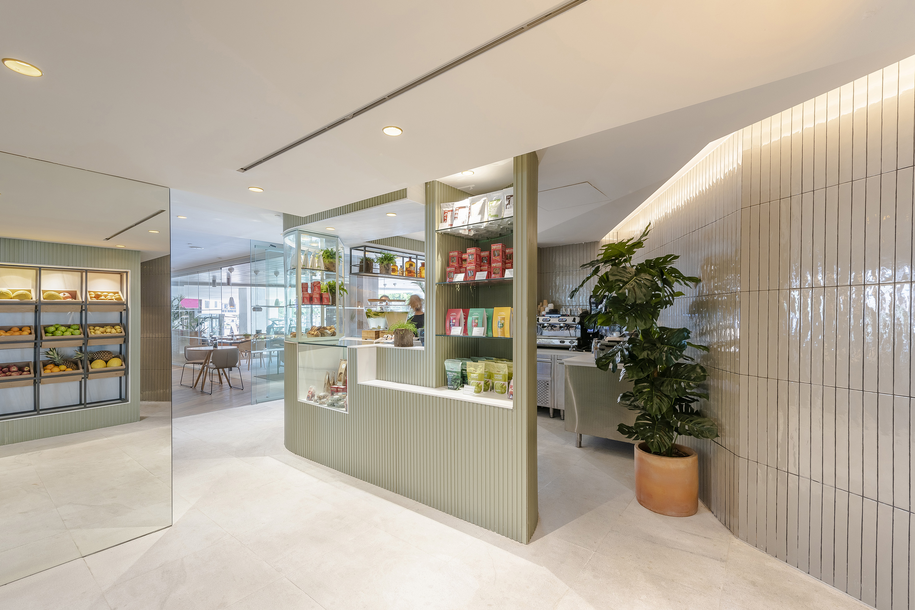 Healthy food cafe with fresh fruit display, coffee bar, and modern green design.