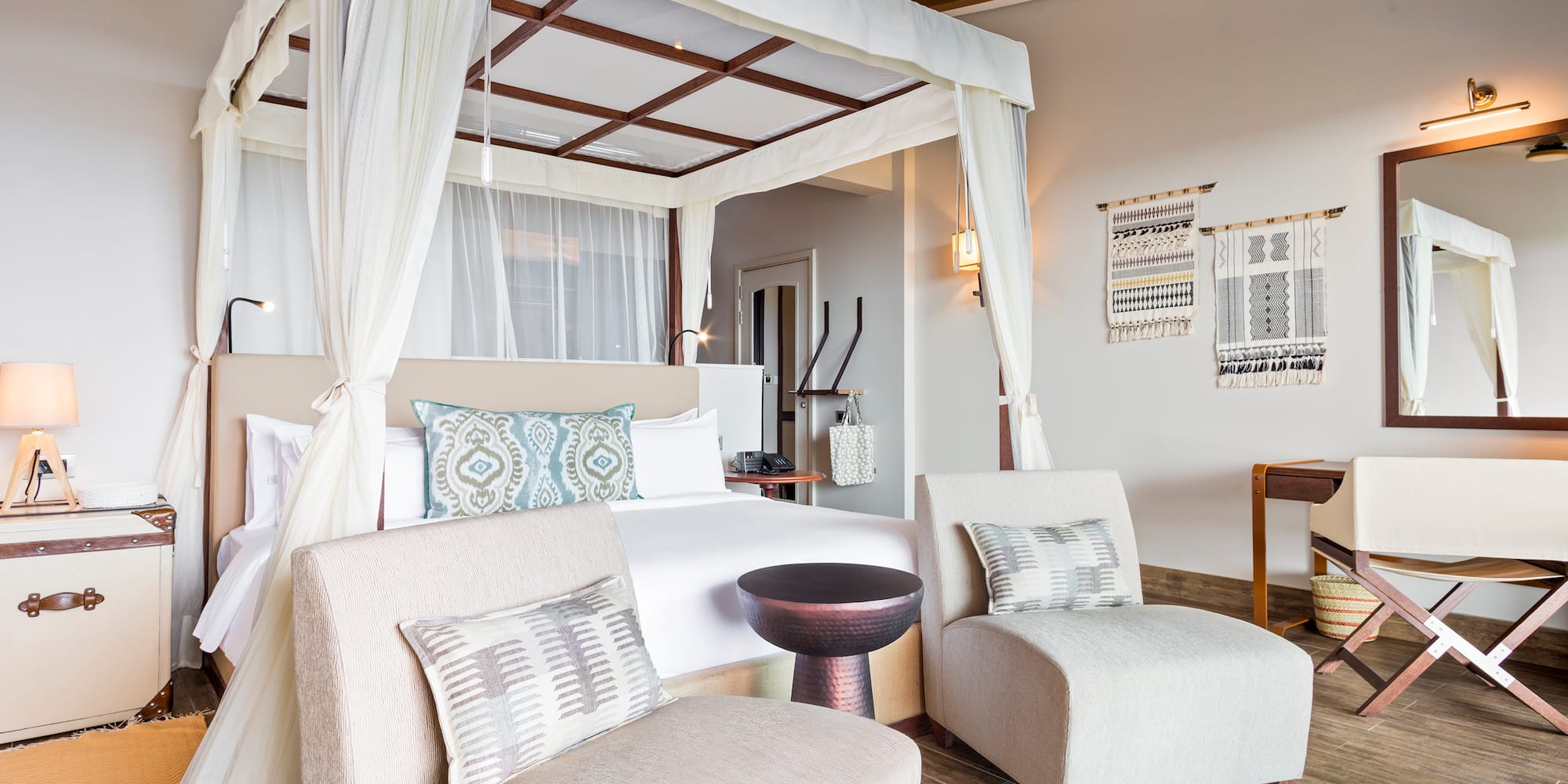 a room with a bed and chairs