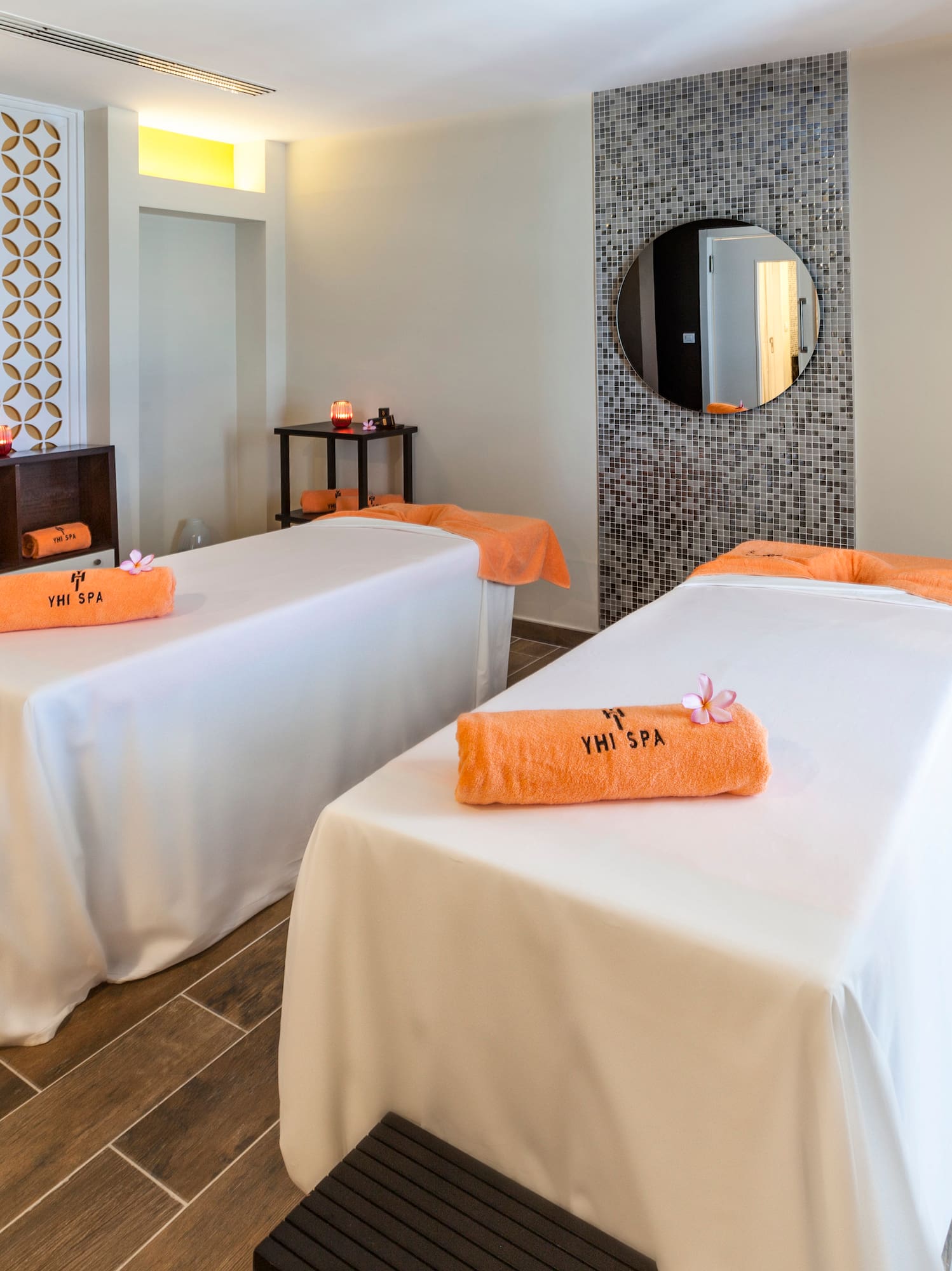 a room with beds and a round mirror