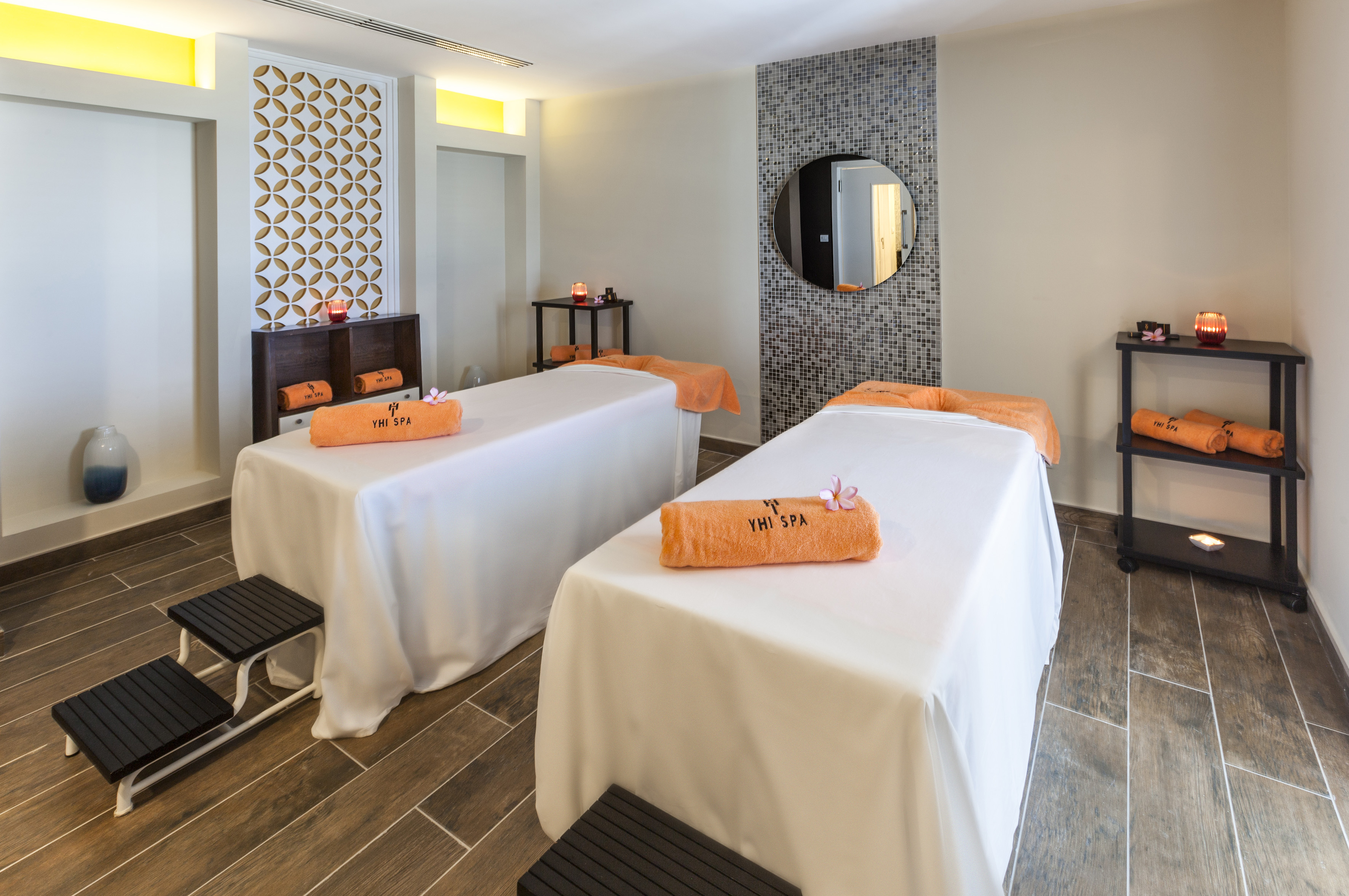 a room with beds and a round mirror