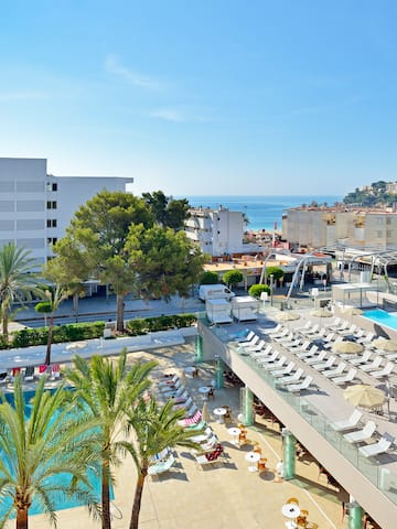 a swimming pool and a building with palm trees