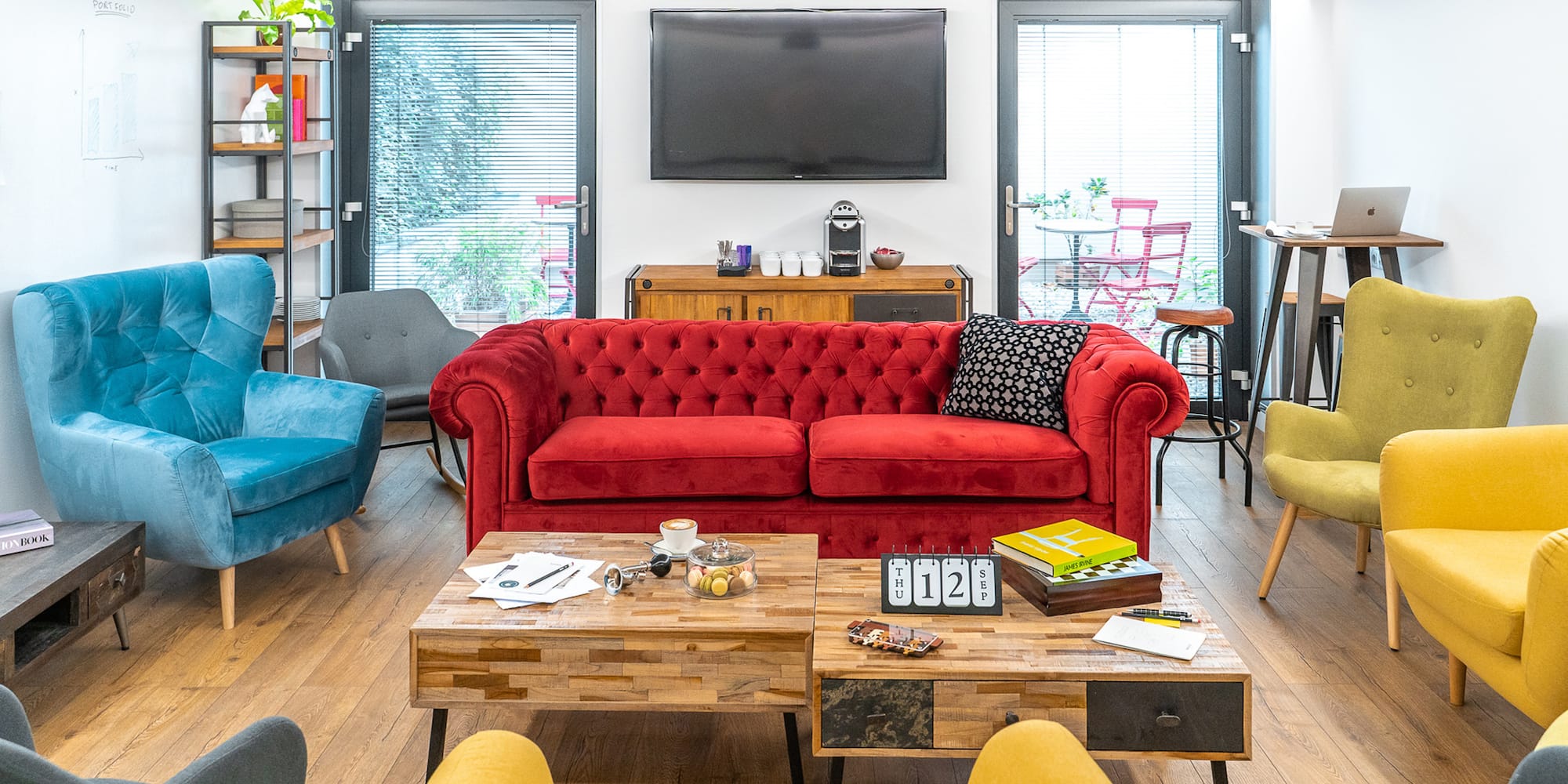 a room with a red couch and blue chairs
