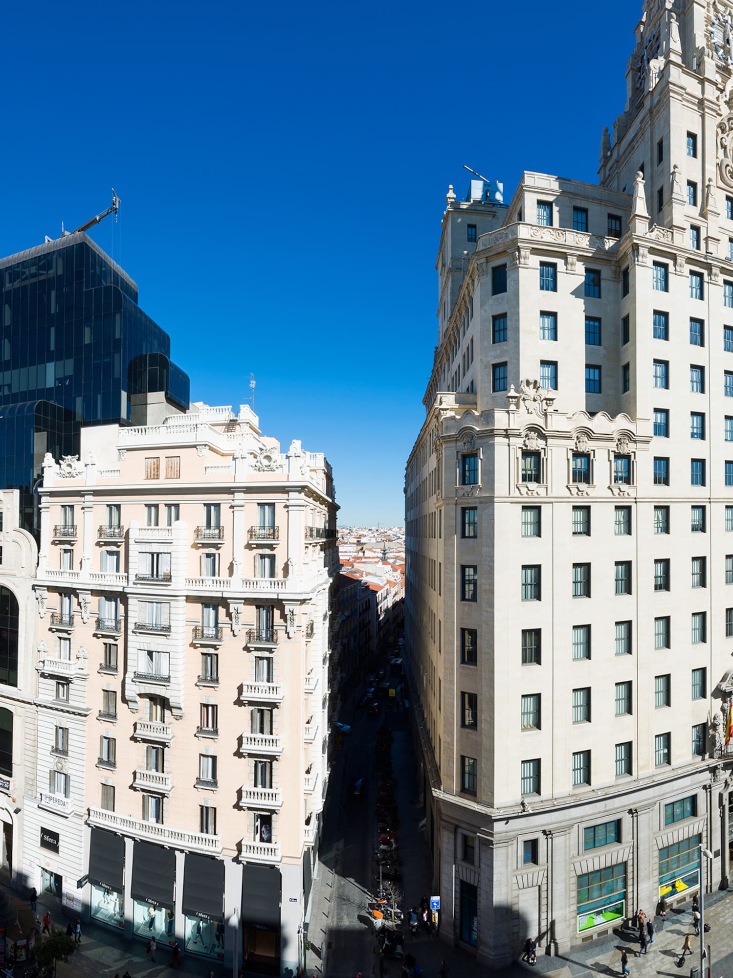 Gran Vía de Madrid: calle urbana, edificios emblemáticos y cielo azul.