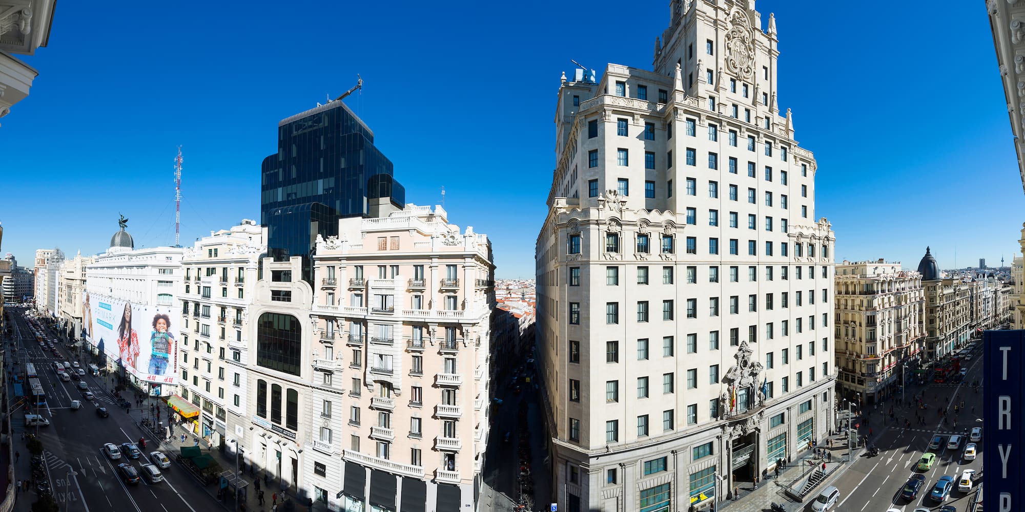 a two tall buildings with a street and a blue sky