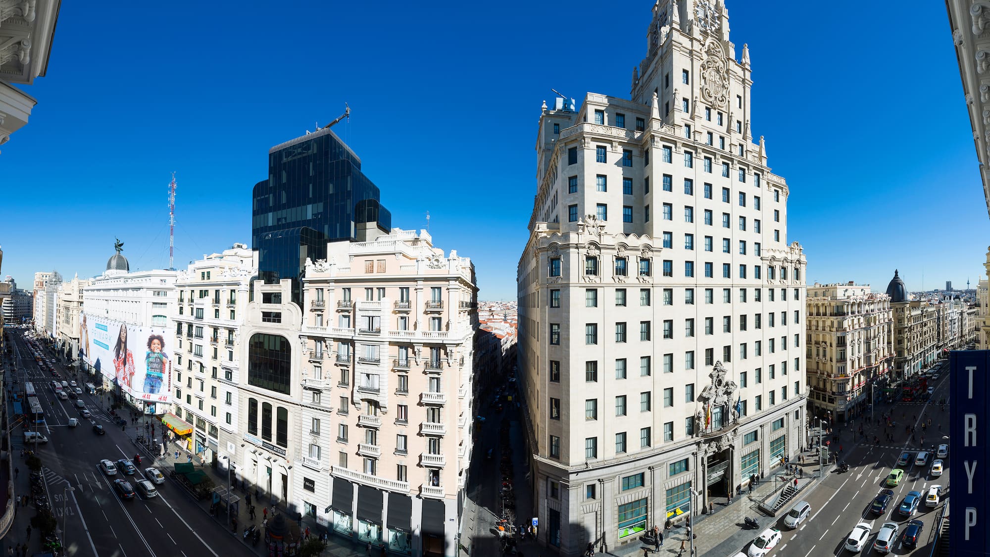 a two tall buildings with a street and a blue sky