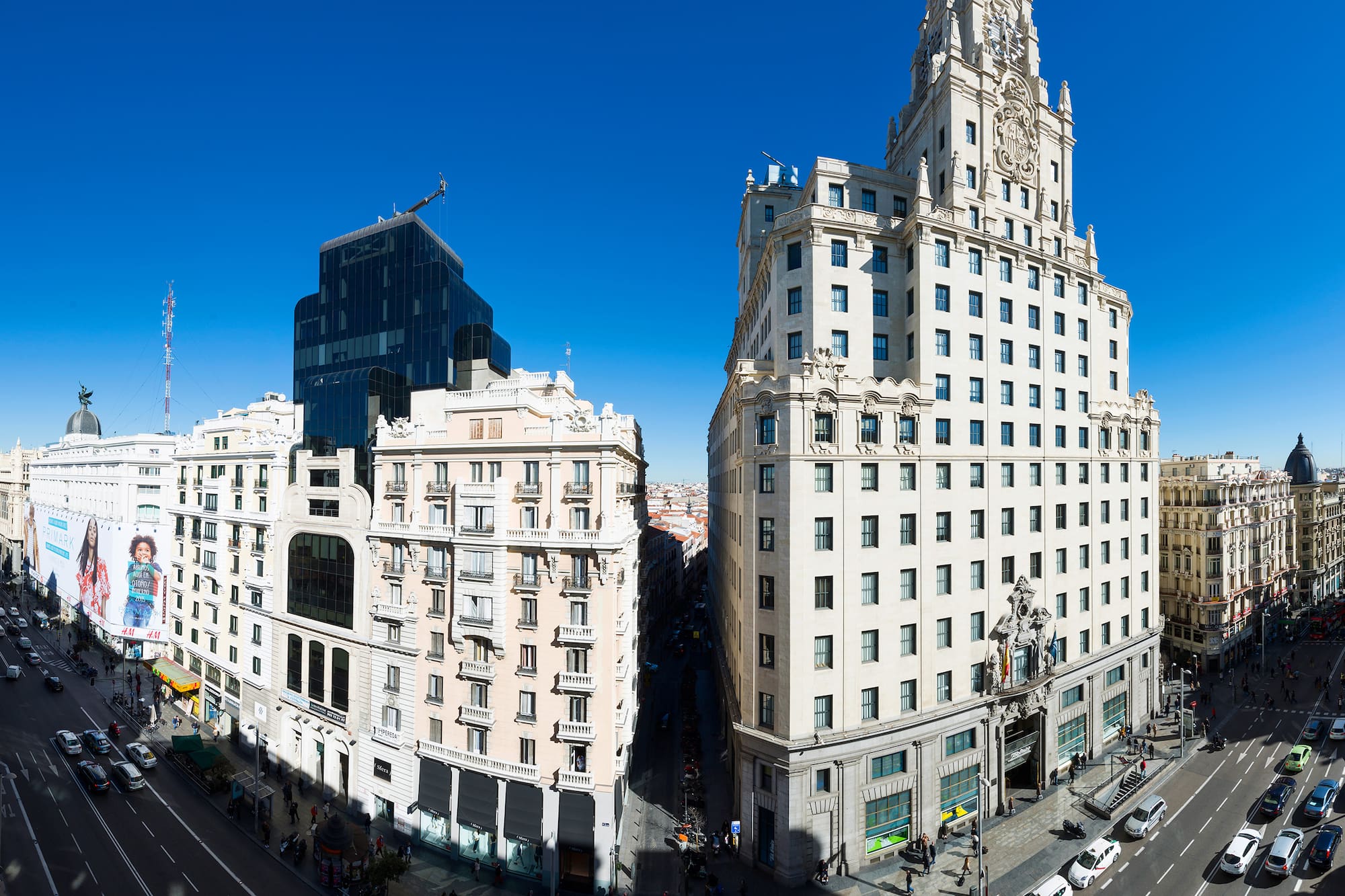 a two tall buildings with a street and a blue sky