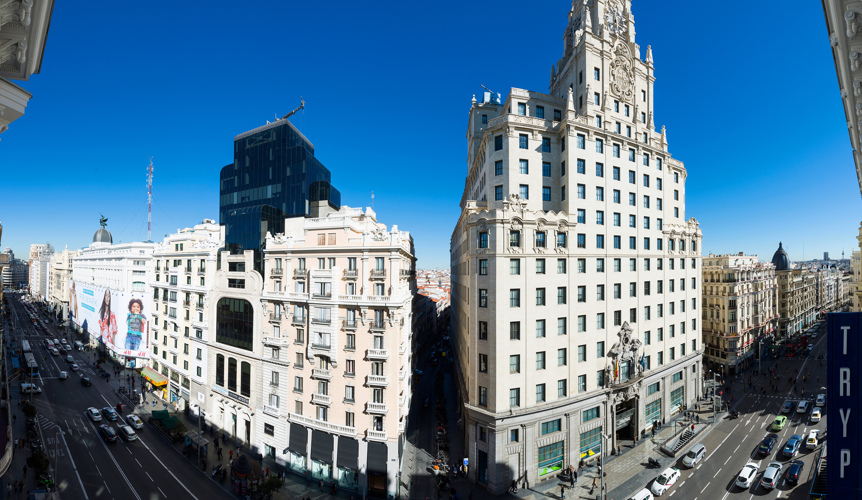 Gran Vía de Madrid: calle urbana, edificios emblemáticos y cielo azul.