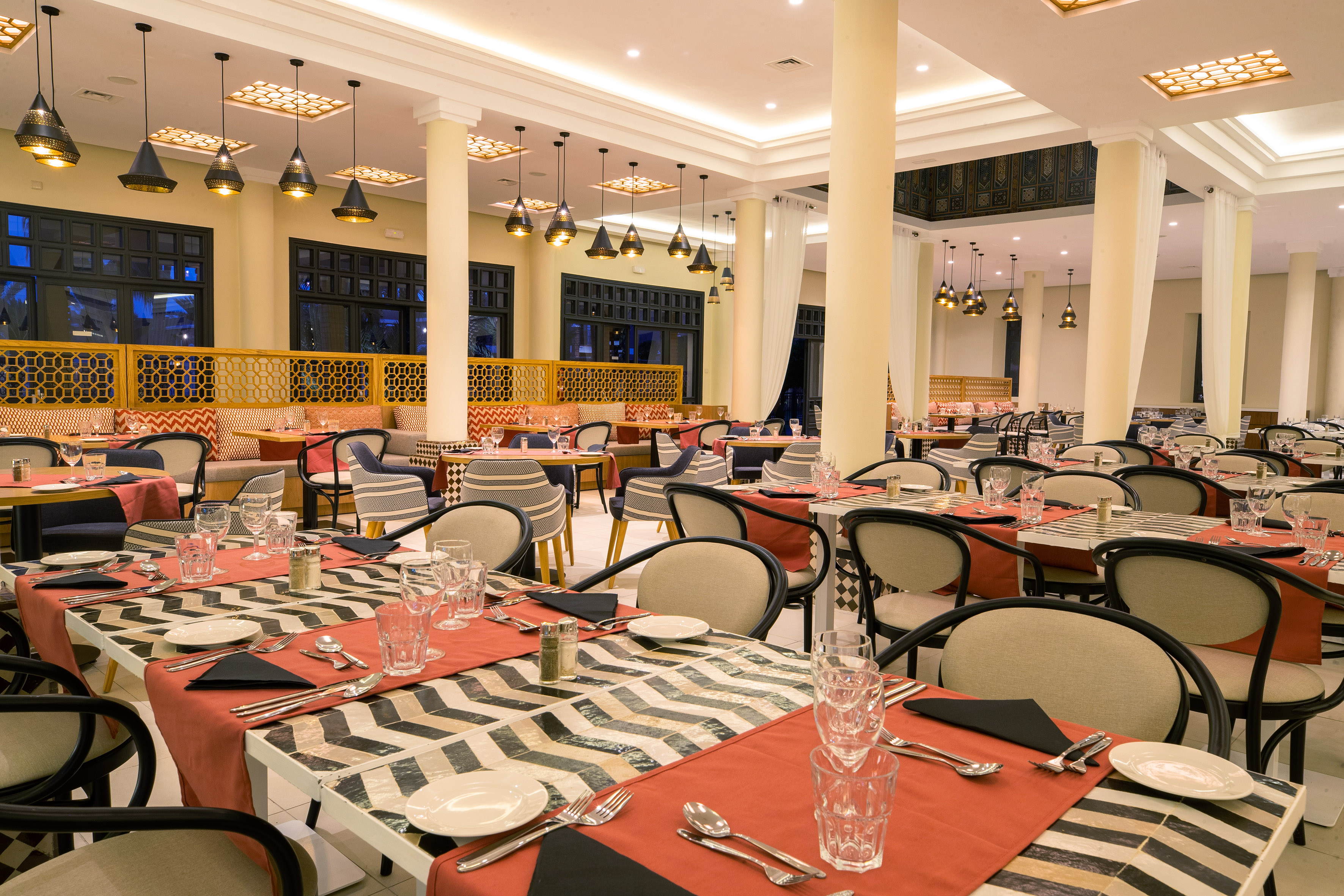 Moroccan restaurant dining room with elegant set tables and patterned decor.