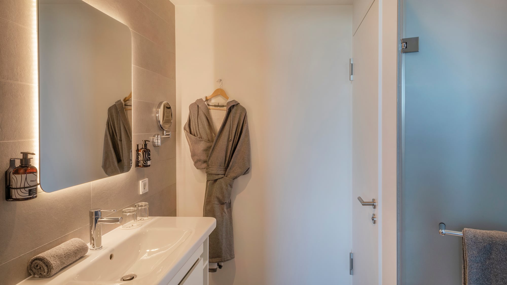 a bathroom with a bathrobe and sink