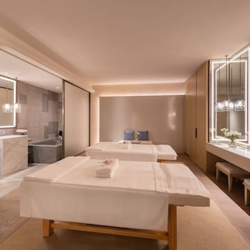 a room with white beds and a bathtub