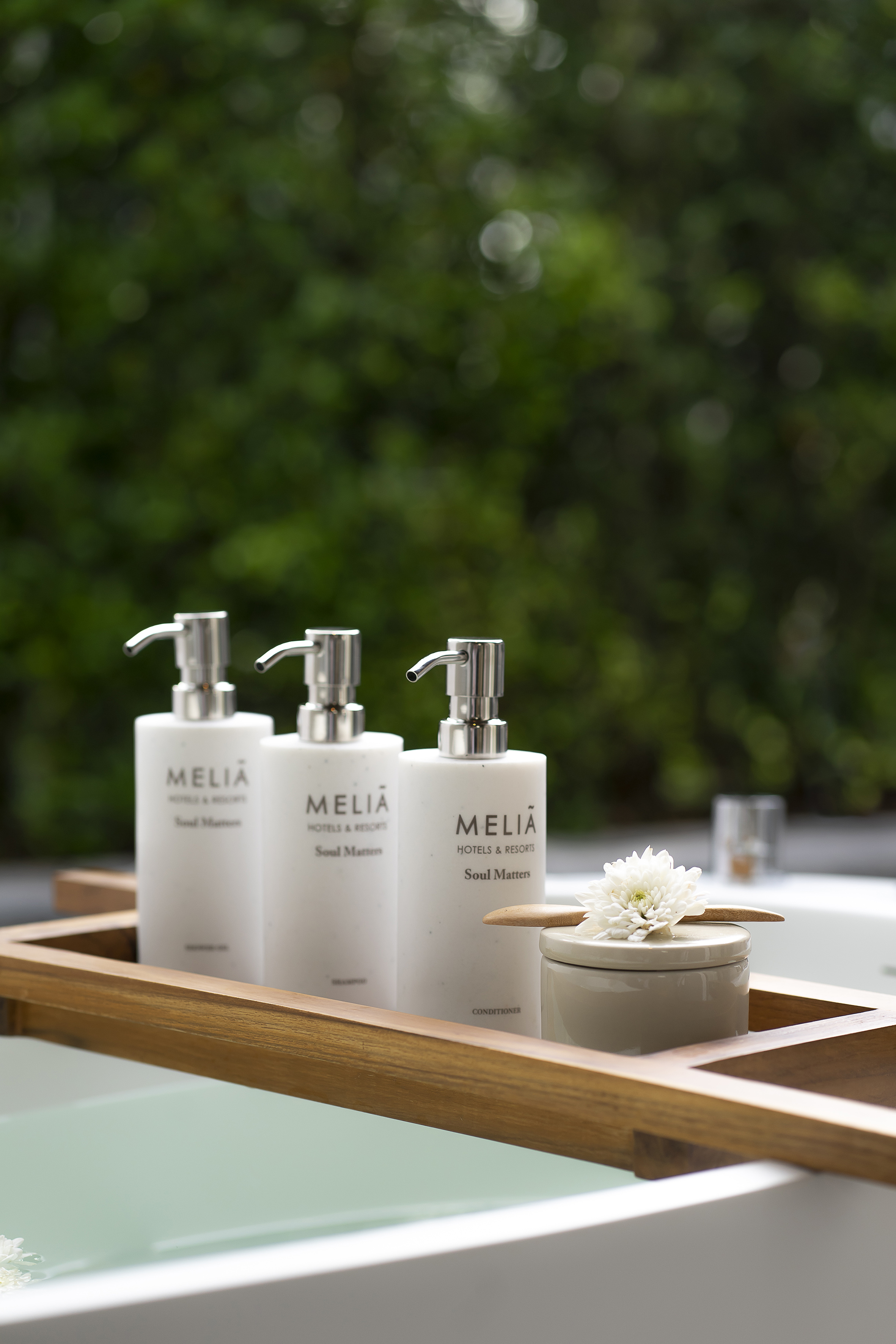 Meliá Soul Matters bath amenities on wooden tray over a bathtub.