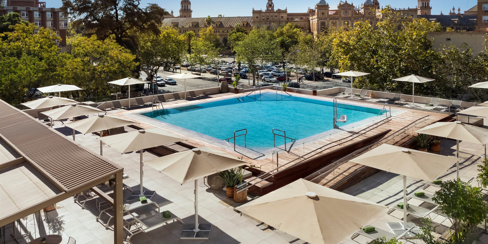a pool with umbrellas and trees in the background