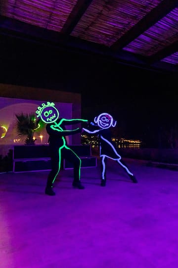 a man and woman dancing with lights