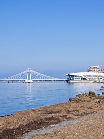 a beach with a bridge and buildings in the background