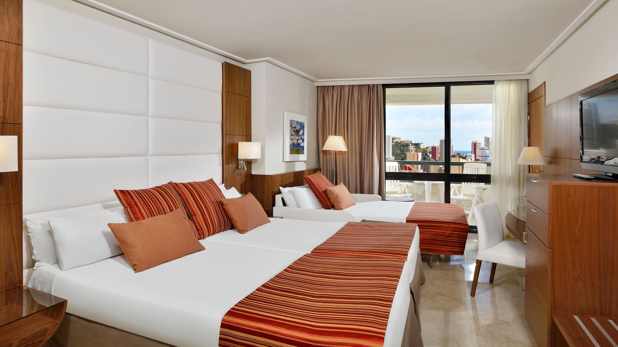 a room with two beds and a balcony