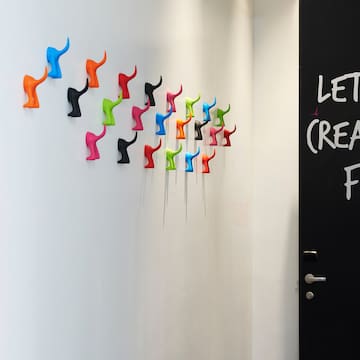 a wall with colorful hooks on it
