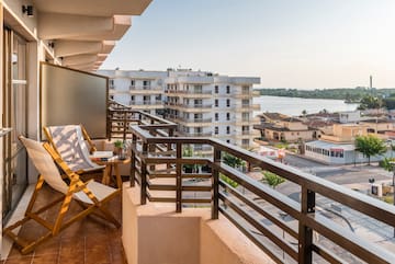 a balcony with chairs and a view of the city
