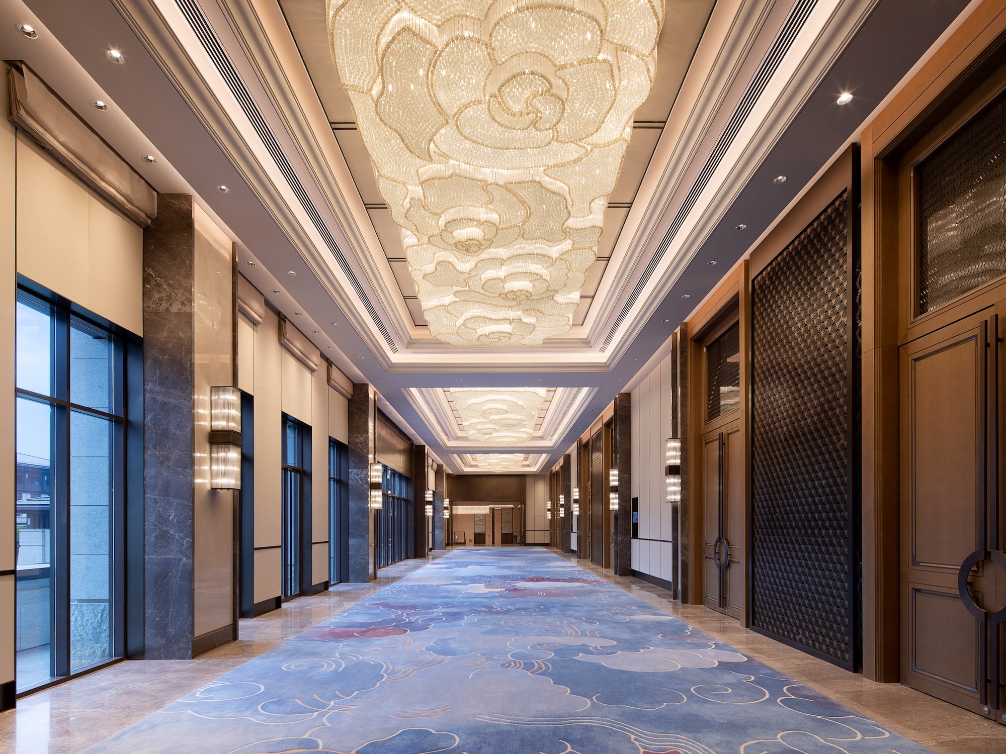 a long hallway with a blue carpet and lights