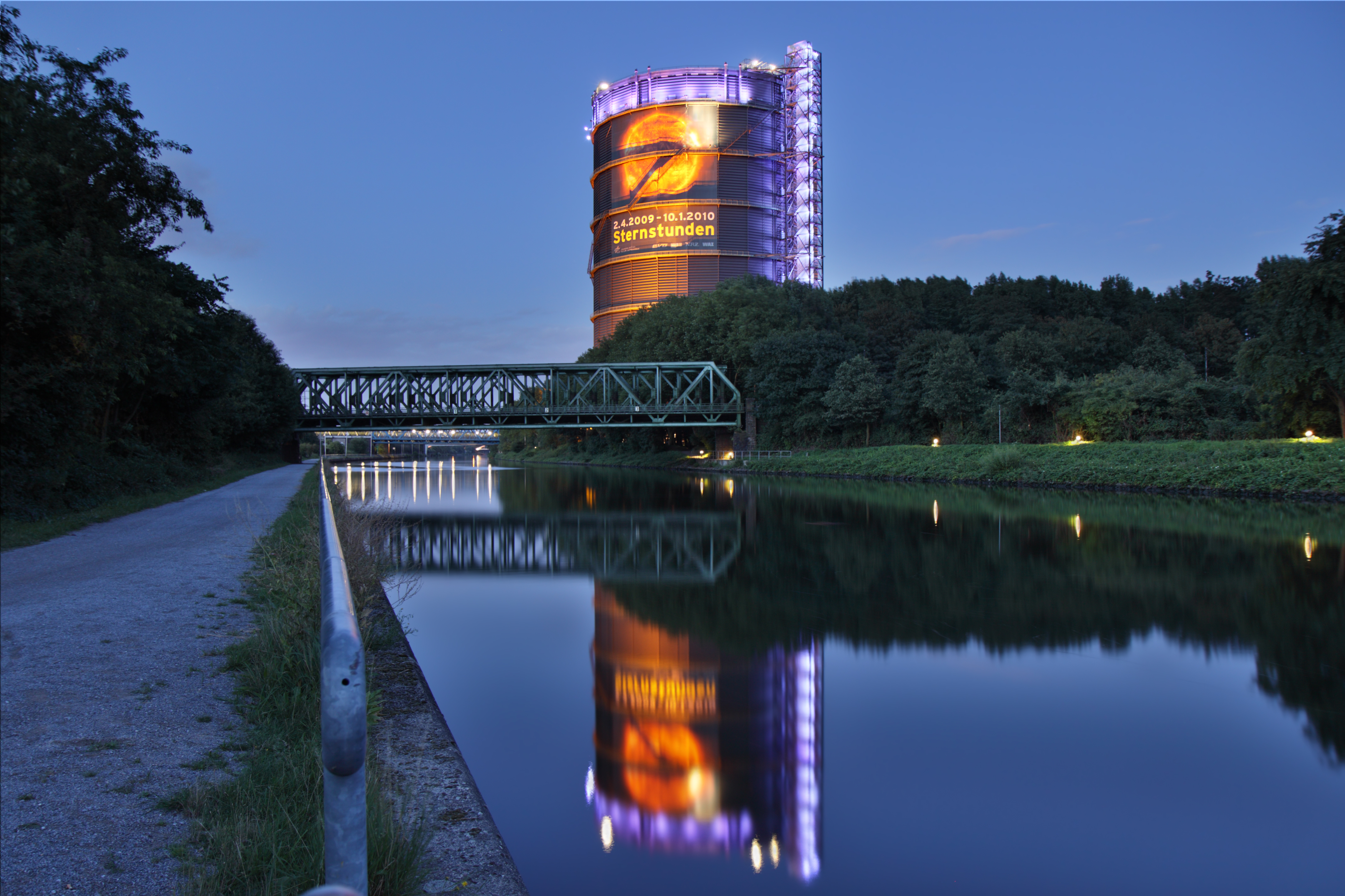 a bridge over a body of water with a large building in the background