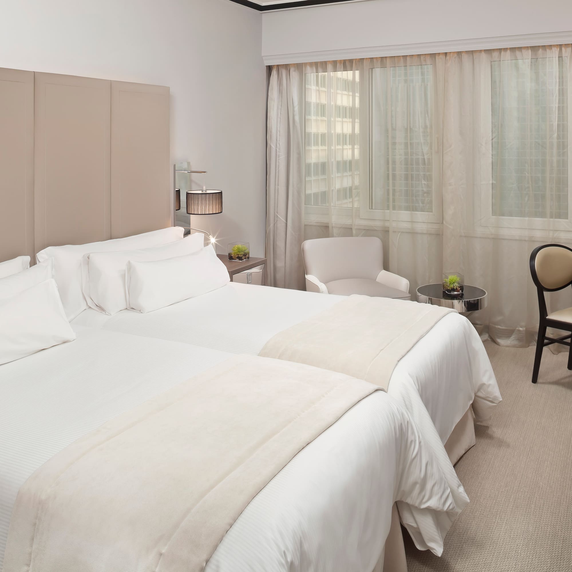 a room with two beds and a chair