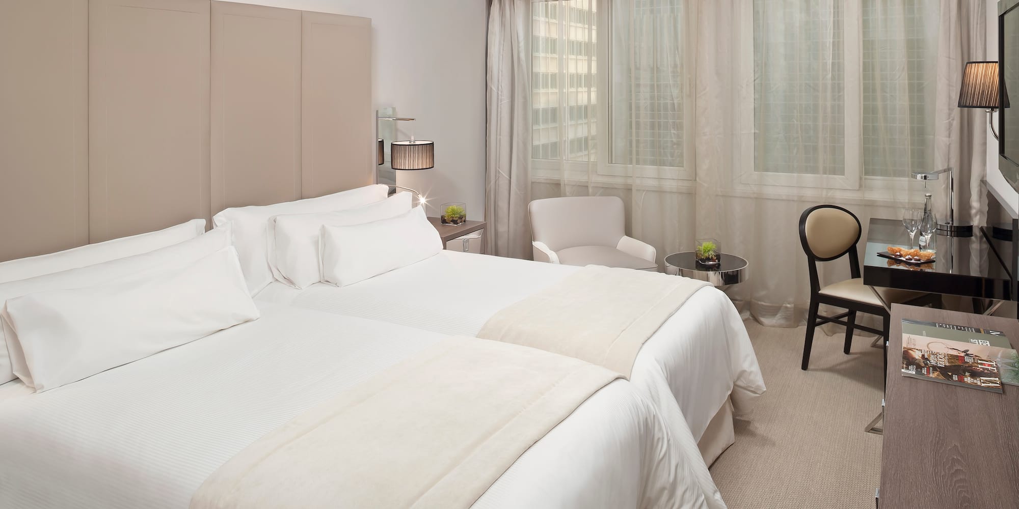 a room with two beds and a chair