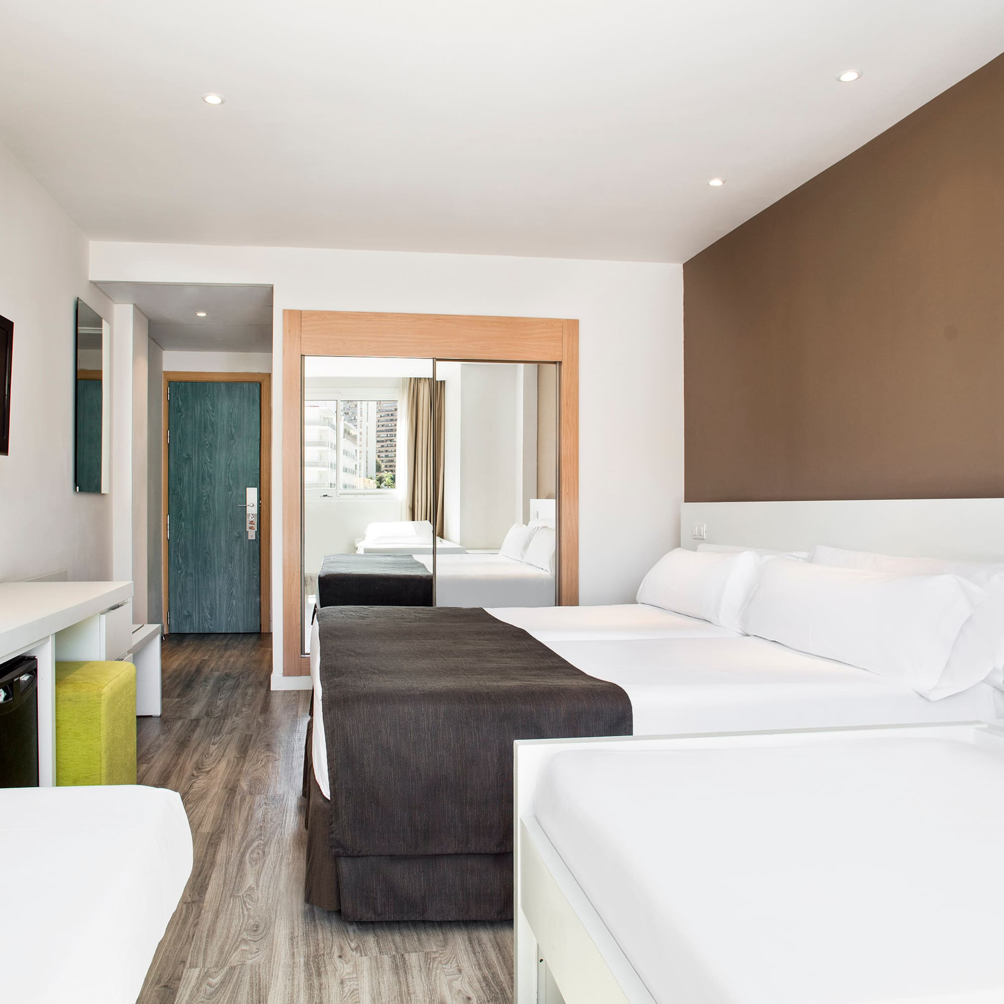 a room with two beds and a mirror