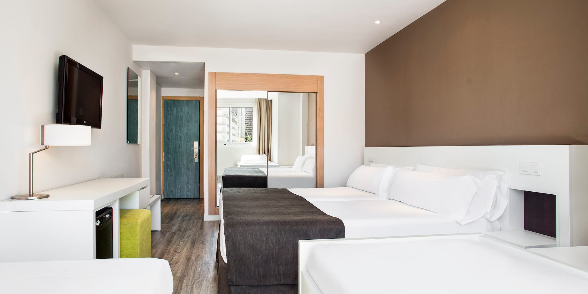 a room with two beds and a mirror