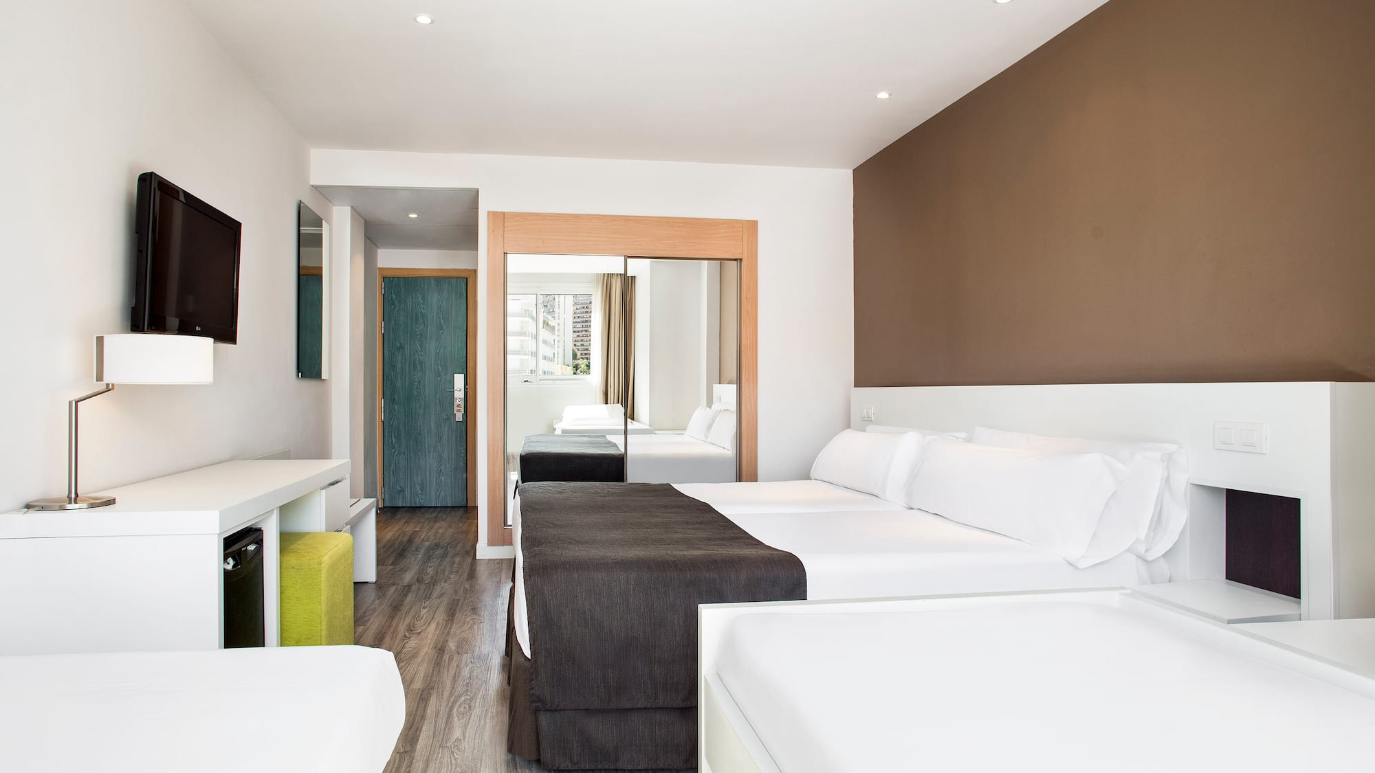 a room with two beds and a mirror