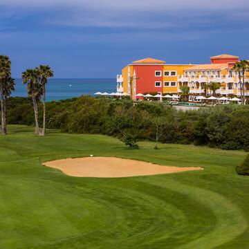 a golf course with a sand trap and palm trees