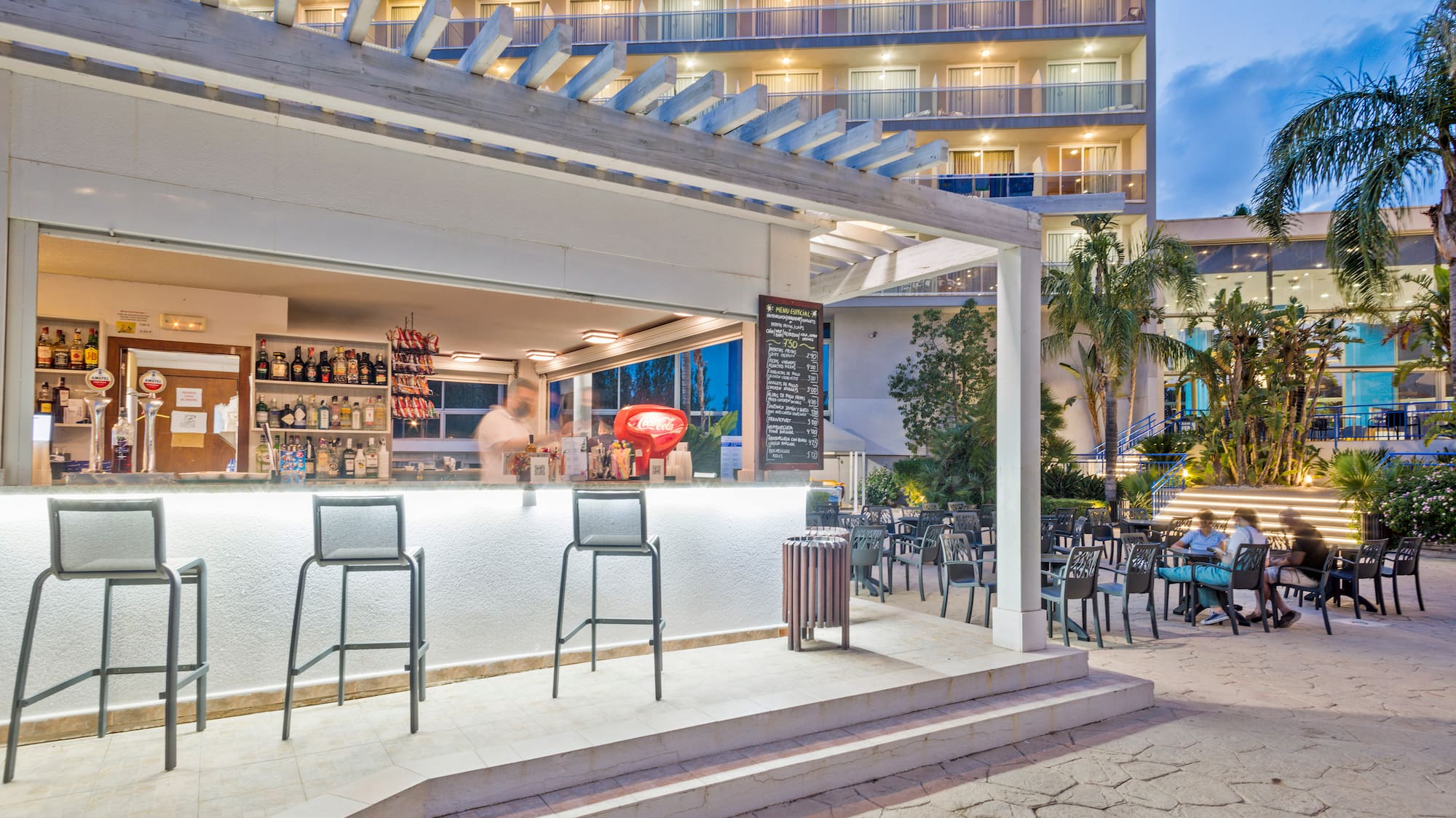 a bar with chairs outside of a building