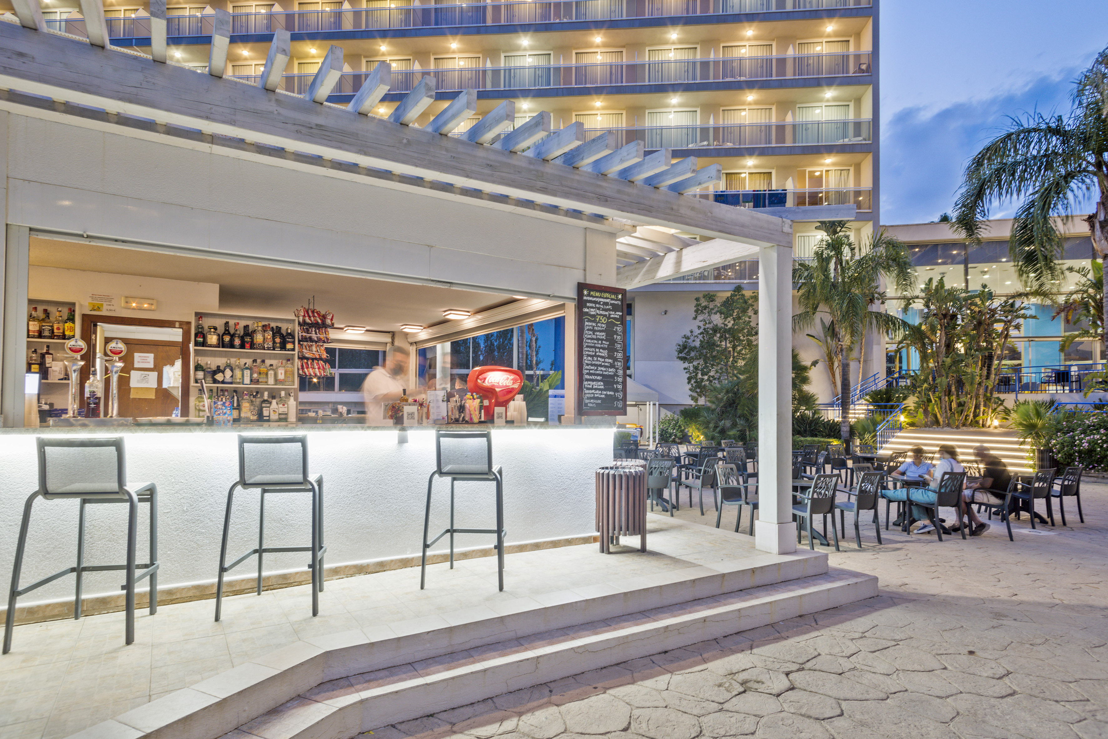 a bar with chairs outside of a building
