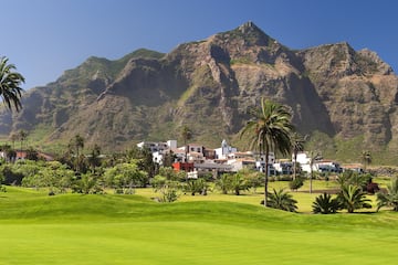 a golf course with a large mountain in the background