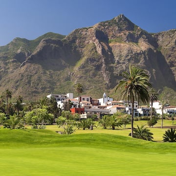 a golf course with a large mountain in the background