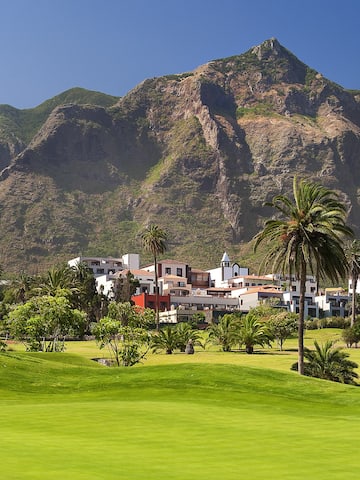 a golf course with a large mountain in the background