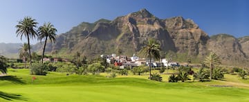 a golf course with a large mountain in the background