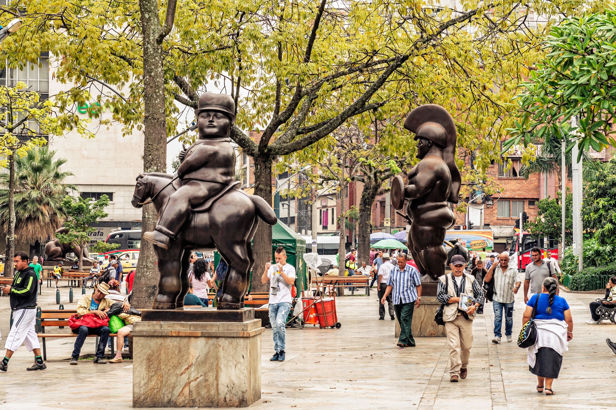 a group of people walking around a statue