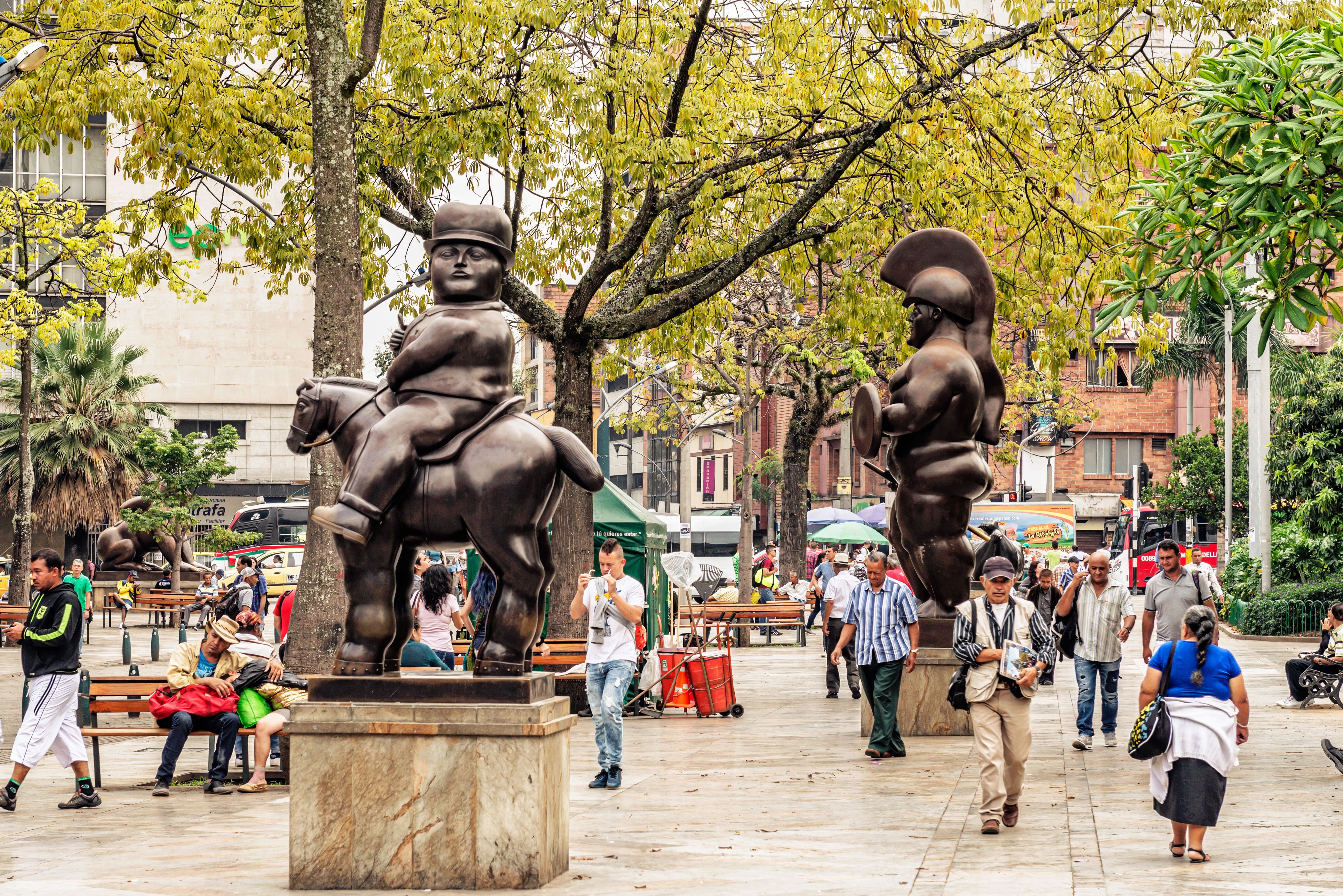 a group of people walking around a statue