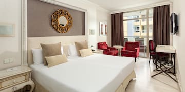 a hotel room with a large bed and chairs